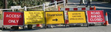Multiple signs st the bottom of Fore Street